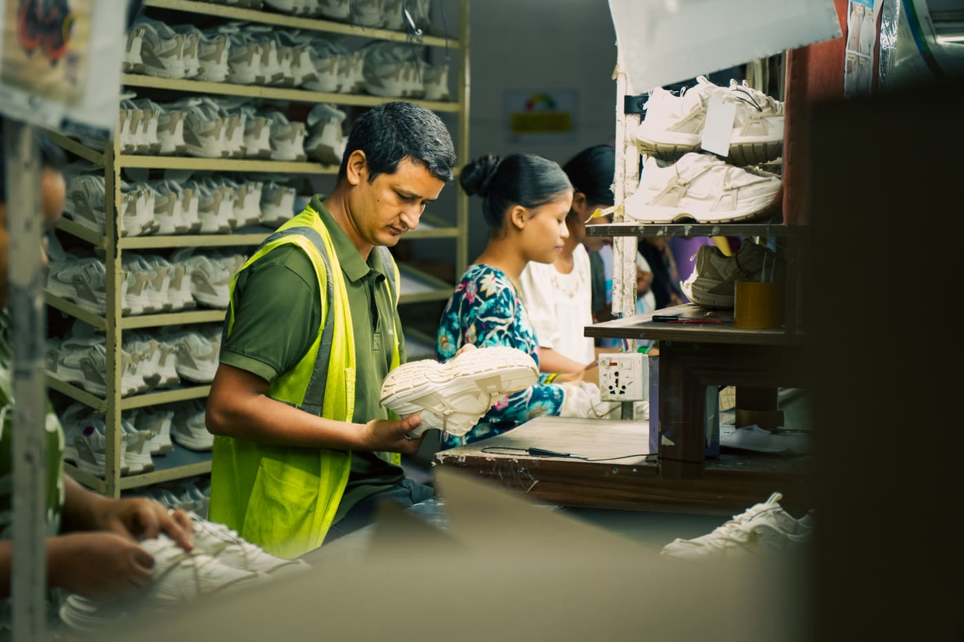 Workers assembling clogs on the production line
